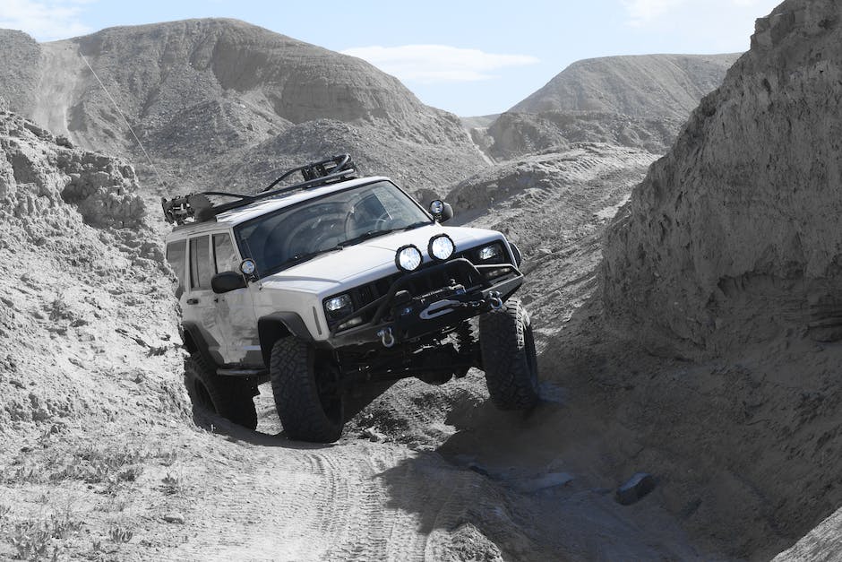 Image of a mechanic working on a Jeep Cherokee's drive-train components. 