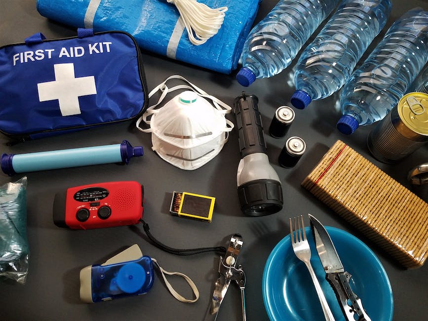 A person preparing a Jeep Cherokee for an emergency, with emergency kit items scattered on the hood of the vehicle