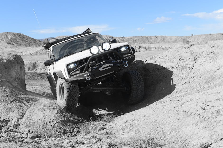 A Jeep Cherokee driving through a rough off-road terrain